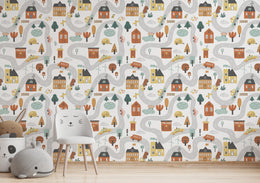 Whimsical town-inspired wallpaper with tiny schools, streets, vehicles, and cozy houses creating cheerful backdrop for playroom